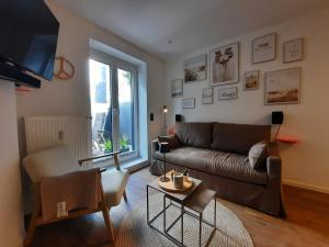 a living room with a couch and a table at Lachmöwe by DeJu -4 Sterne DTV-Klassifizierung- in Norderney