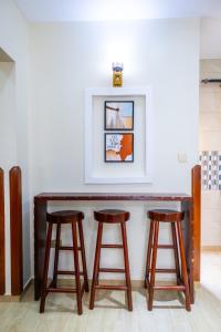 a wooden bar with two stools in a room at The Cozy Nest in Kampala