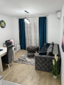 a living room with a black couch and a table at Apartman Savic in Vrnjačka Banja