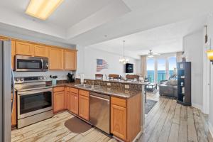 フォート・ウォルトン・ビーチにあるBeach Front White Sands Getaway 503, Free Activities Included!のキッチン(木製キャビネット、ステンレス製の電化製品付)
