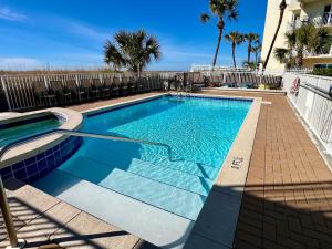 フォート・ウォルトン・ビーチにあるBeach Front White Sands Getaway 503, Free Activities Included!の建物の前の青い水のプール