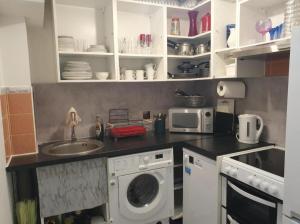 a kitchen with a washing machine and a sink at GBliss Spacious Apartment in Guildford