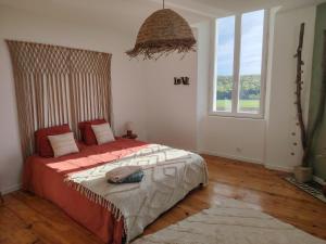 a bedroom with a bed and a large window at La Tour XVIII in Sarrouilles
