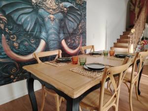 a table with chairs and an elephant mural on the wall at La Tour XVIII in Sarrouilles