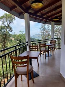 un balcon avec tables et chaises et une vue dans l'établissement Hillwood Resort & Restaurant, à Hewaheta 16 autres photos