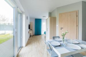 a dining room with a white table and chairs at Villa Blanca in Grzybowo +56 photos