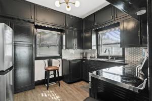 セント・オーガスティンにあるPacific Cove 9 - Unique Pet-Friendly Bungalowの黒いキャビネットと椅子付きのキッチン