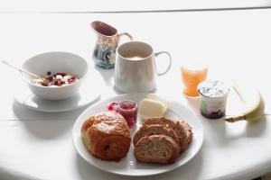 a table with a plate of bread and a cup of coffee at Chez Camille et Pierre in Bourgvallées