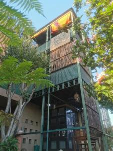 a building with a balcony with trees in front of it at Mordillo House in Johannesburg