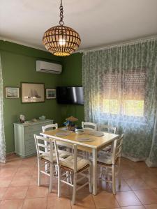 a dining room with a table and chairs at FILANGERI 116 in Santa Flavia