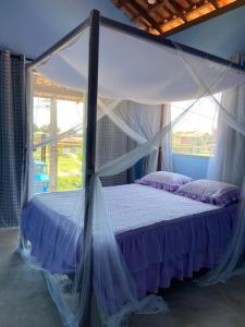 クムルサティバにあるCasa verdeのベッドルーム1室(天蓋付きベッド1台、窓付)