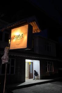 uma pessoa sentada em frente a uma placa em um prédio em Samyee inn em Lachung