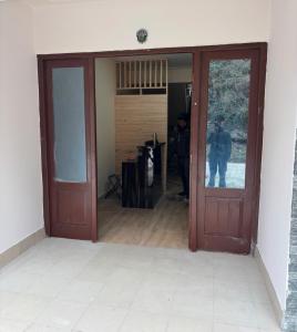 uma porta aberta para uma sala com duas pessoas paradas na porta em Samyee inn em Lachung