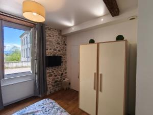a bedroom with a white refrigerator and a window at Studio RUBIS Quartier du Château in Pau