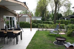 a patio with a table and chairs on a lawn at Rondomzon in Voorthuizen