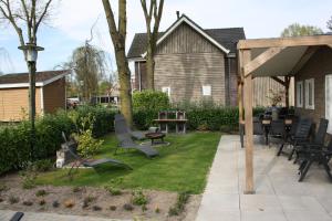a patio with chairs and tables in a yard at Rondomzon in Voorthuizen