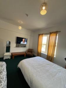 a hotel room with a bed and a flat screen tv at Eva lodges in Manchester