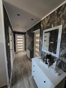 a living room with a white dresser and a mirror at u eli i jurka in Sztutowo +105 photos