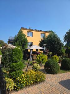 a garden with an umbrella and a building at u eli i jurka in Sztutowo