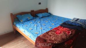 a bed with blue comforter with bees on it at Hari Har guest house in Chhatarpur
