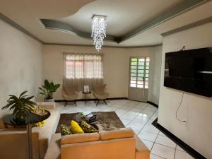 a living room with a couch and a flat screen tv at Casa do umbuzeiro in Bom Jesus da Lapa