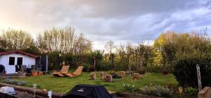 a garden with chairs and a house in the background at Ferienapartment Haus am Grün 3 "Sunset" - Ruhe & Entspannung mitten in der Natur in Herzberg am Harz