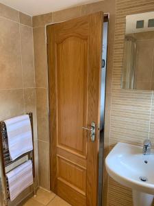 a bathroom with a wooden door and a sink at The Granary, Upper Largo in Kirkton of Largo +26 photos