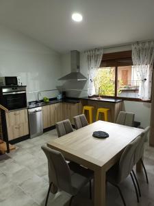 a kitchen with a wooden table and chairs at Él Rincón de los Sueños B in Vegadecabo +9 photos