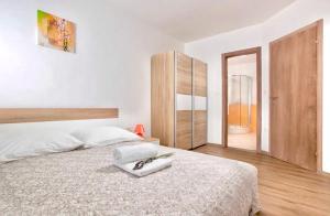 een slaapkamer met een groot wit bed met een houten hoofdeinde bij Villa Alternus-apartman Dora in Ičići +24 foto's