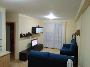 a living room with a blue couch and a television at Vivienda Vacacional Mirador de La Villa in San Sebastián de la Gomera
