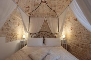 a bedroom with a canopy bed with two white pillows at Ántika suite & spa in Castellana Grotte