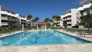 a swimming pool in front of some apartment buildings at Caribbean Zen at Bosque Del Mar - Las Picuas - Rio Grande in Rio Grande