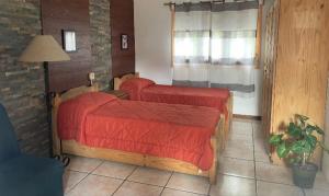 a bedroom with two beds with red sheets and a window at Casa Color in Florida