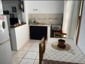 a small kitchen with a table and a refrigerator at Casa Color in Florida