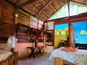a room with a bed and a large window at Wildlife Lodge Cahuita in Cahuita