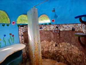 a bathroom with a shower and a blue wall at Wildlife Lodge Cahuita in Cahuita
