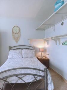 a bedroom with a bed with a clock on the wall at Tziimin Nahil Cozumel in Cozumel