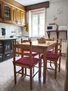 a kitchen with a wooden table and some chairs at Casa Macías in Lago de Carucedo