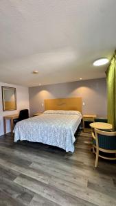 a bedroom with a bed and a table and chairs at Chisholm's Motor Inn in Saugus