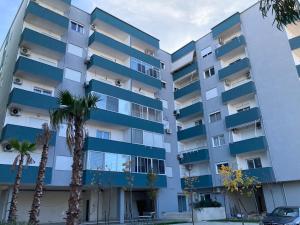 an apartment building with palm trees in front of it at Romantic Sunset&Seaview Apartment in Golem +18 photos