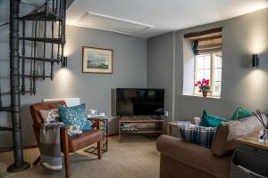 a living room with a couch and a television at The Cotswolds Hidden Gem in Moreton in Marsh