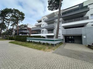 a large building with a tree in front of it at Morski z ogródkiem in Pogorzelica