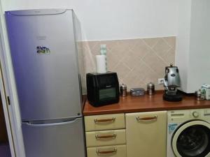 a kitchen with a refrigerator and a microwave at Casadaema in Acerra