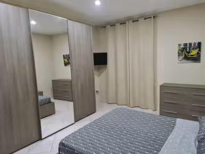 a bedroom with a bed and a dresser and a mirror at Casadaema in Acerra