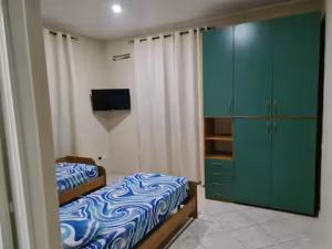 a bedroom with a bed and a green cabinet at Casadaema in Acerra