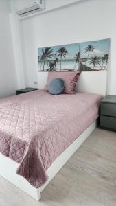 a bedroom with a large bed with a pink comforter at Primavera Pipera Plaza in Voluntari