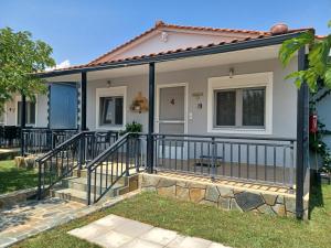 a home with a metal railing and a porch at Kerkini Houses in Kerkíni