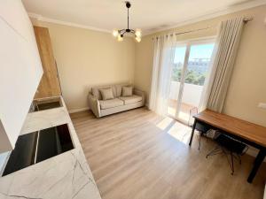 a living room with a white couch and a piano at Romantic Sunset&Seaview Apartment in Golem