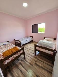 a room with three beds and a flat screen tv at Ninho Verde Holiday Home in Quadra