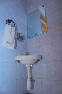 a bathroom with a white sink and a mirror at 3 Jays Homes in Narok +5 photos